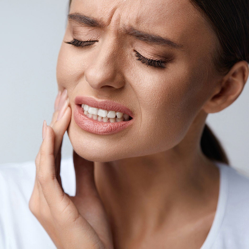 A woman experiencing tooth sensitivity pain